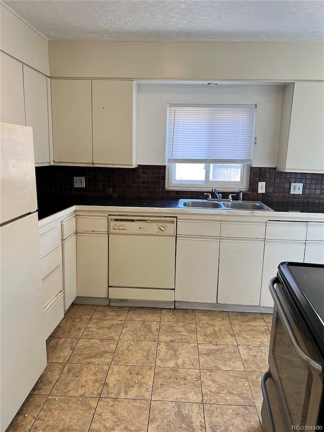 kitchen with white appliances, tasteful backsplash, sink, and light tile floors