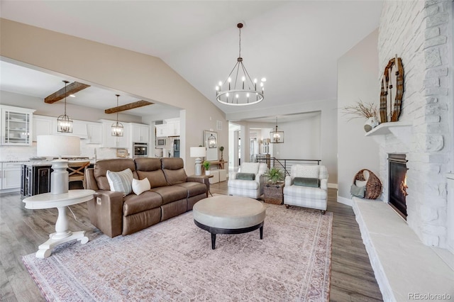 360 Basilwood Way, Highlands Ranch, CO 80126 - living room featuring a chandelier, wood finished floors, a stone fireplace, and vaulted ceiling