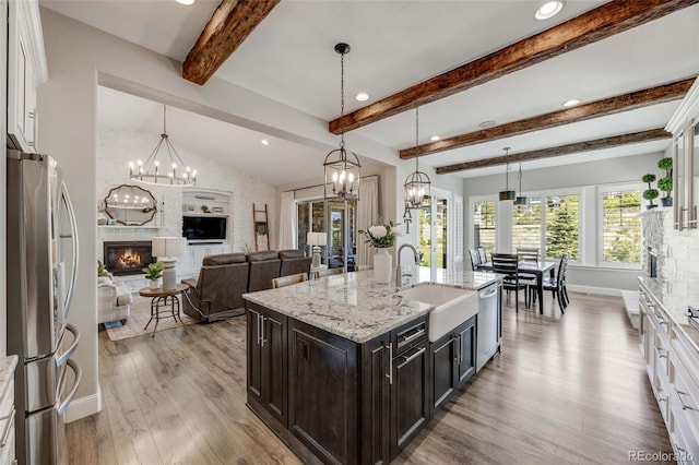 360 Basilwood Way, Highlands Ranch, CO 80126 - kitchen with appliances with stainless steel finishes, recessed lighting, light wood-style floors, a glass covered fireplace, and white cabinets