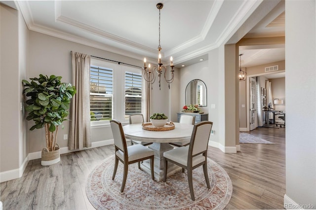 360 Basilwood Way, Highlands Ranch, CO 80126 - dining room featuring a chandelier, a raised ceiling, light wood-style floors, and ornamental molding