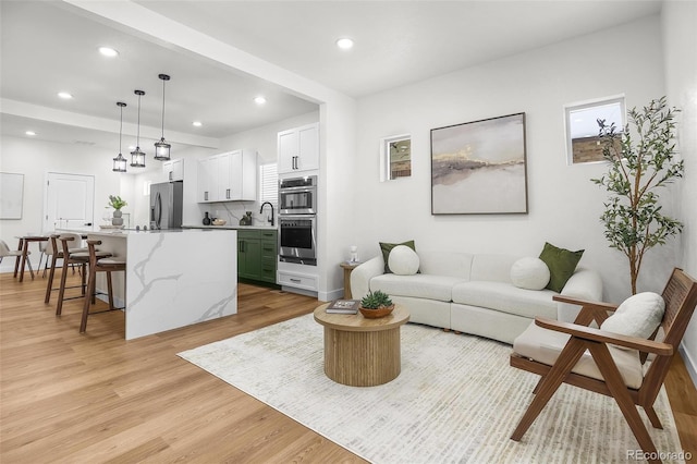 living room featuring sink and light hardwood / wood-style flooring