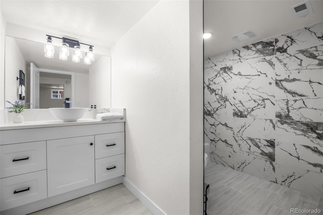 bathroom featuring a tile shower and vanity