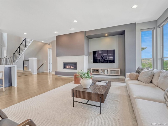 9395 Night Star Pl, Lone Tree, CO 80124 - living area with wood finished floors, plenty of natural light, a glass covered fireplace, recessed lighting, and stairs