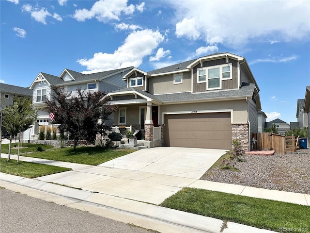 craftsman-style house featuring a garage, covered porch, and a front yard