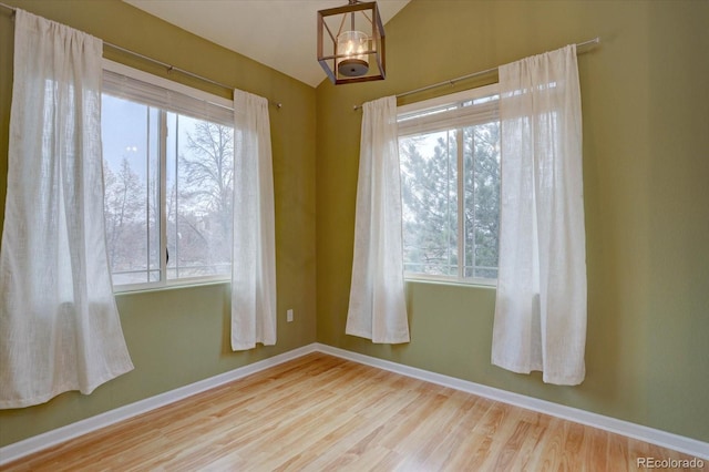 empty room featuring baseboards and wood finished floors