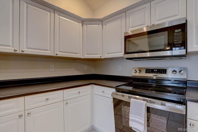 kitchen with dark countertops, white cabinets, and stainless steel appliances