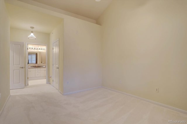 unfurnished room featuring light carpet and baseboards