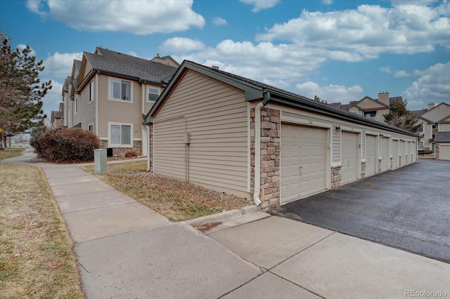 view of home's exterior with stone siding and community garages