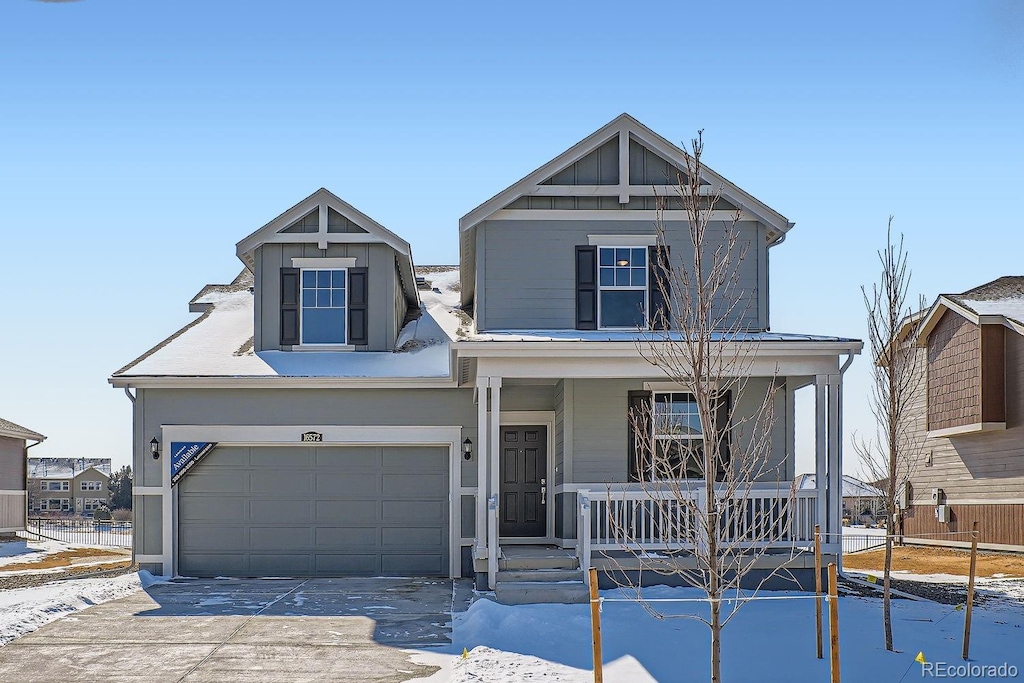 view of front facade featuring covered porch, concrete driveway, and a garage