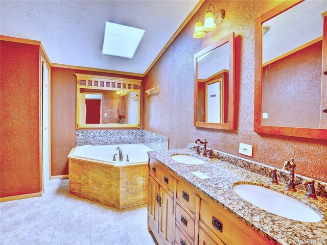 full bathroom featuring a skylight, a textured wall, and a sink