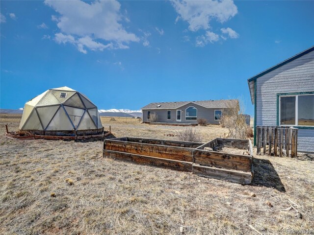 view of yard featuring an exterior structure, a garden, and an outdoor structure