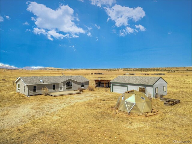 rear view of house featuring a deck with mountain view, a rural view, and an outdoor structure