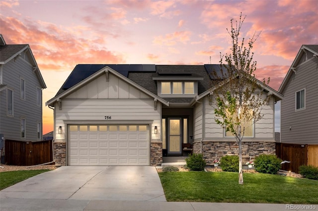 craftsman-style home featuring stone siding, concrete driveway, and solar panels