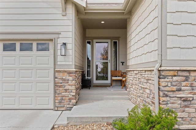 doorway to property with stone siding and a garage