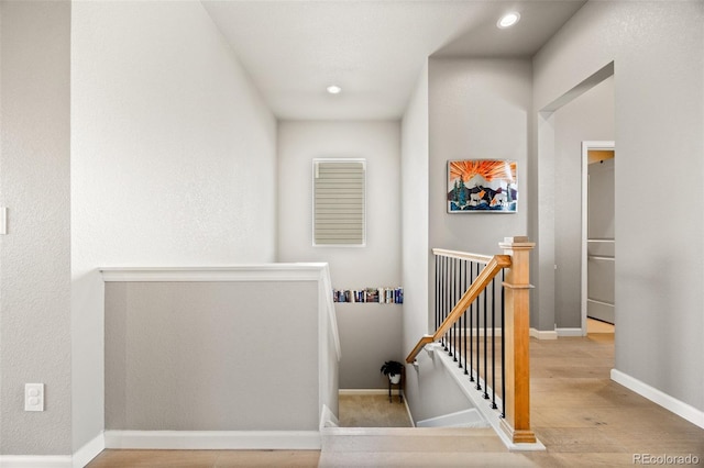 staircase with wood finished floors, recessed lighting, and baseboards