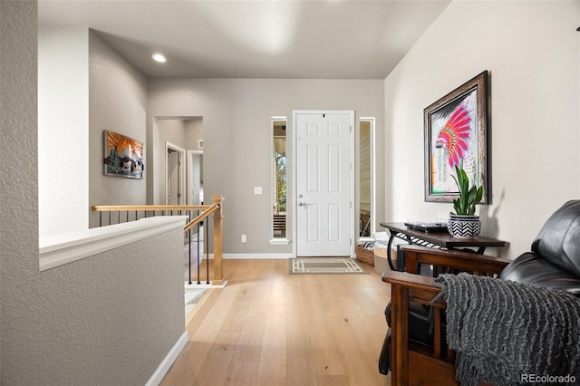 foyer featuring light wood finished floors, baseboards, and recessed lighting