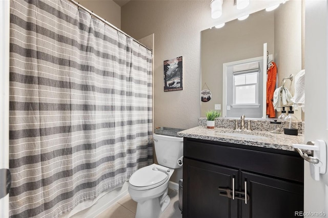 full bathroom with toilet, tile patterned floors, vanity, a textured wall, and a shower with shower curtain