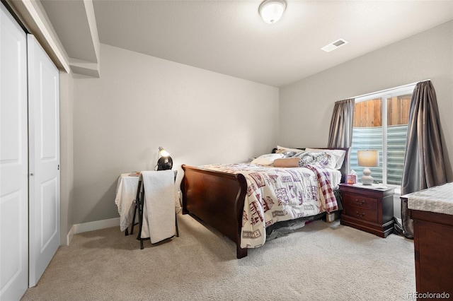 bedroom with light carpet, a closet, and baseboards