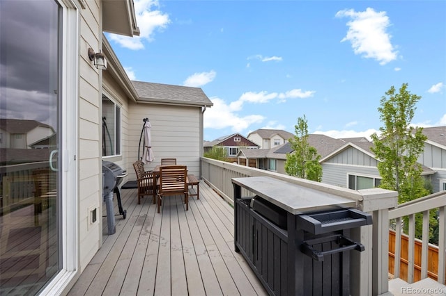 wooden deck with outdoor dining area, a residential view, and grilling area