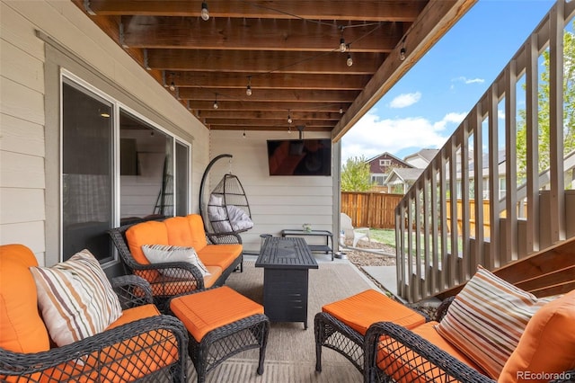 view of patio / terrace featuring an outdoor hangout area, stairs, and fence