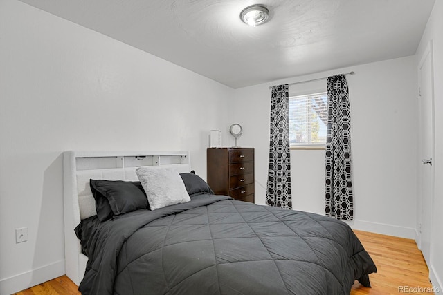 bedroom with baseboards and wood finished floors