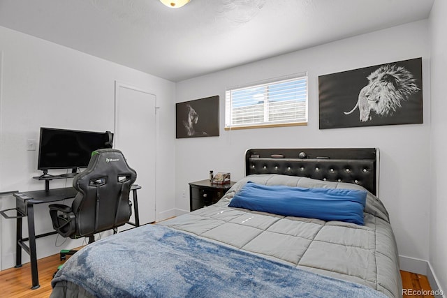 bedroom with wood finished floors and baseboards