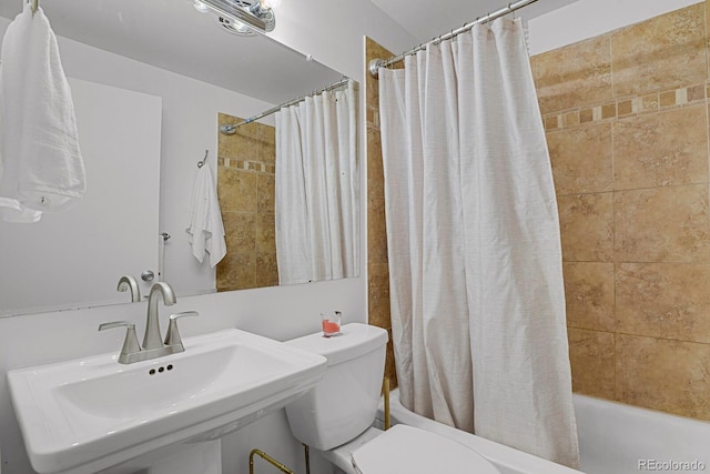 bathroom with shower / tub combo, a sink, and toilet