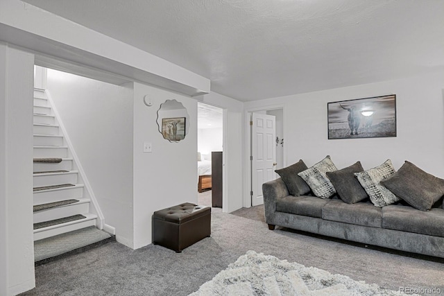 living room featuring carpet floors, a textured ceiling, and stairs