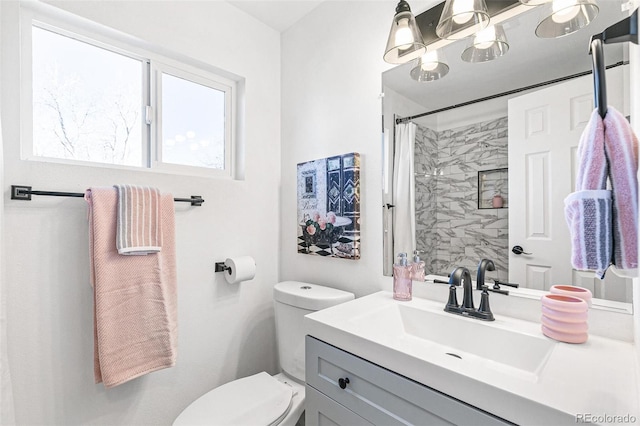 bathroom featuring toilet, vanity, and curtained shower