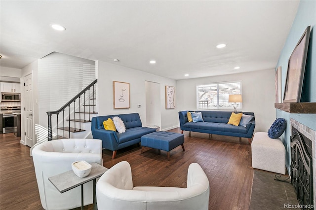 living room with a brick fireplace and dark hardwood / wood-style floors