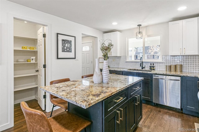 kitchen featuring a kitchen island, sink, hanging light fixtures, dark hardwood / wood-style floors, and stainless steel dishwasher