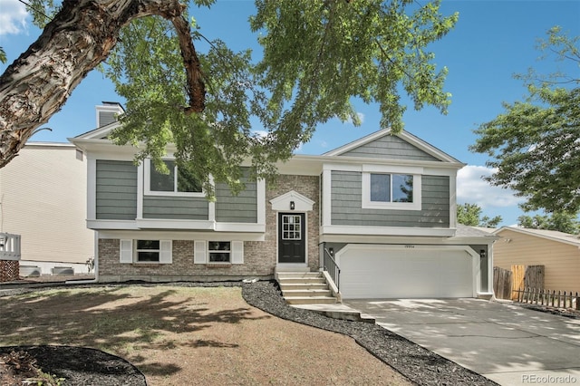 19954 E Dartmouth Ave, Aurora, CO 80013 - split foyer home with a garage, driveway, a chimney, and brick siding
