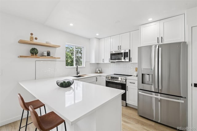 19954 E Dartmouth Ave, Aurora, CO 80013 - kitchen featuring stainless steel appliances, a kitchen breakfast bar, light countertops, tasteful backsplash, and white cabinetry