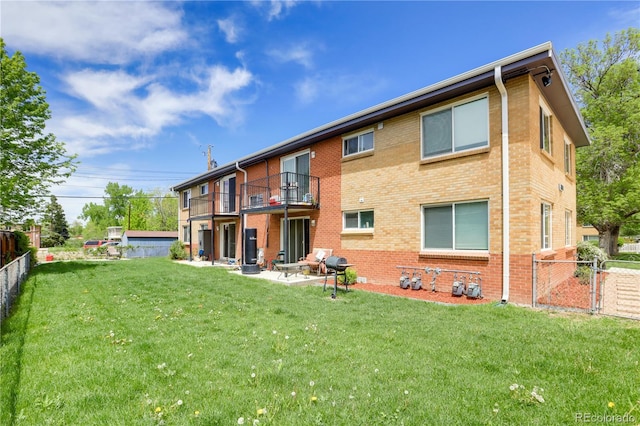 10491 W 7th Pl, Lakewood, CO 80215 - back of house featuring a balcony, brick siding, and a patio area
