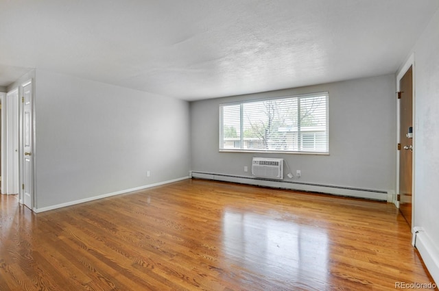 10491 W 7th Pl, Lakewood, CO 80215 - spare room featuring wood finished floors, a baseboard radiator, and a wall mounted AC