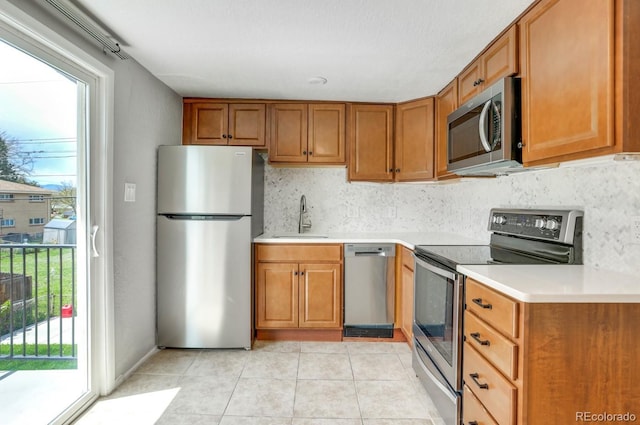 10491 W 7th Pl, Lakewood, CO 80215 - kitchen featuring stainless steel appliances, a sink, brown cabinets, and light countertops