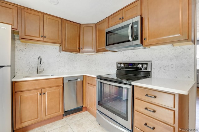 10491 W 7th Pl, Lakewood, CO 80215 - kitchen featuring appliances with stainless steel finishes, a sink, light countertops, and decorative backsplash