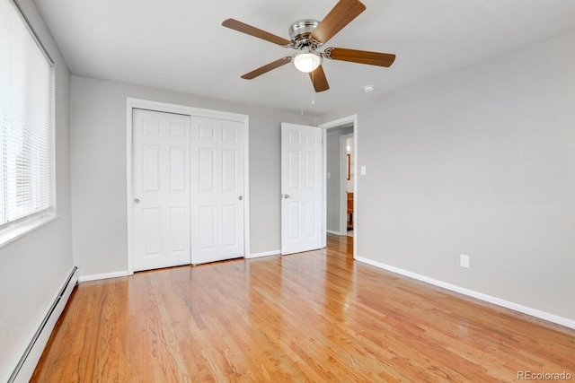10491 W 7th Pl, Lakewood, CO 80215 - unfurnished bedroom with baseboard heating, baseboards, light wood finished floors, and a closet