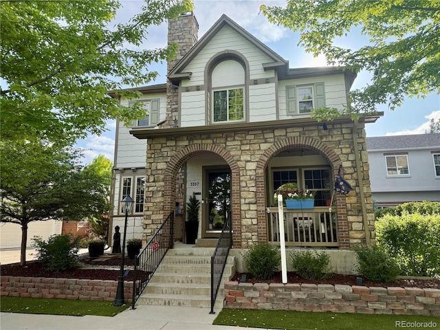 3357 N Akron Ct, Denver, CO 80238 - view of front of house with stone siding, a chimney, and a porch