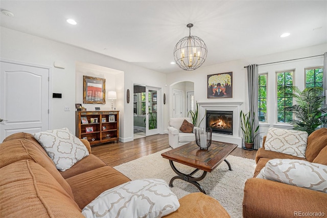 3357 N Akron Ct, Denver, CO 80238 - living room featuring arched walkways, a chandelier, recessed lighting, wood finished floors, and a glass covered fireplace