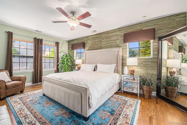3357 N Akron Ct, Denver, CO 80238 - bedroom with an accent wall, wood finished floors, and a ceiling fan