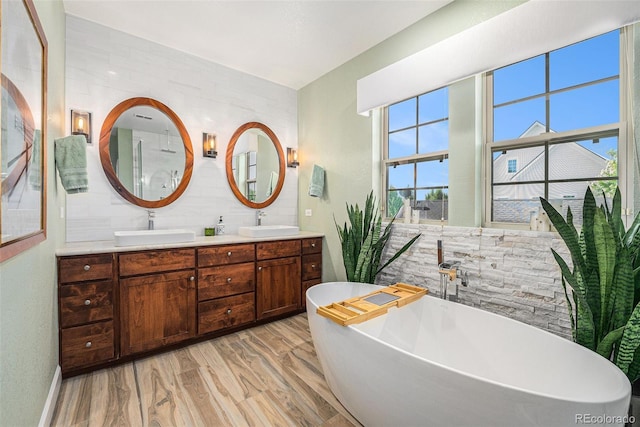 3357 N Akron Ct, Denver, CO 80238 - bathroom with double vanity, a freestanding tub, wood finished floors, and backsplash