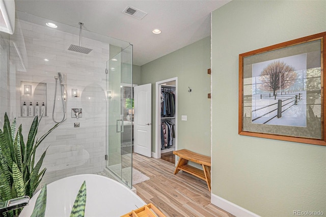 3357 N Akron Ct, Denver, CO 80238 - bathroom with a shower stall, a freestanding tub, wood finished floors, a spacious closet, and recessed lighting