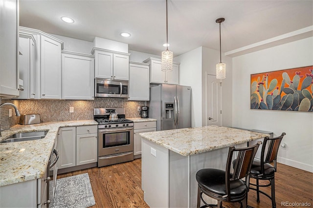 3357 N Akron Ct, Denver, CO 80238 - kitchen with appliances with stainless steel finishes, dark wood-style flooring, backsplash, a kitchen breakfast bar, and recessed lighting