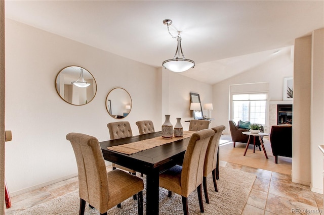 1530 S Quebec Way Unit 29, Denver, CO 80231 - dining space featuring vaulted ceiling, baseboards, and a tiled fireplace