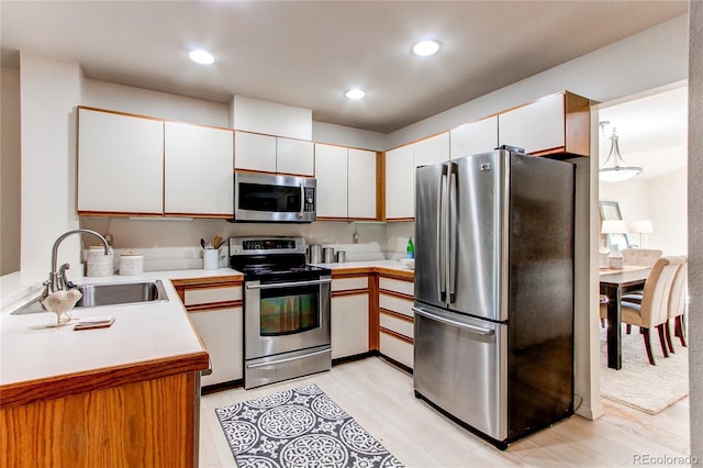 1530 S Quebec Way Unit 29, Denver, CO 80231 - kitchen featuring light wood finished floors, a sink, light countertops, appliances with stainless steel finishes, and recessed lighting