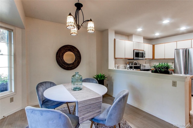 1530 S Quebec Way Unit 29, Denver, CO 80231 - dining space featuring light wood finished floors, a chandelier, baseboards, and recessed lighting