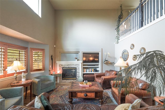 919 Taylor Ln, Erie, CO 80516 - living area featuring a high ceiling, a stone fireplace, and wood finished floors