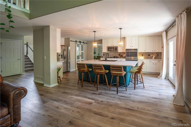 919 Taylor Ln, Erie, CO 80516 - dining room with a barn door, light wood-style flooring, and stairway