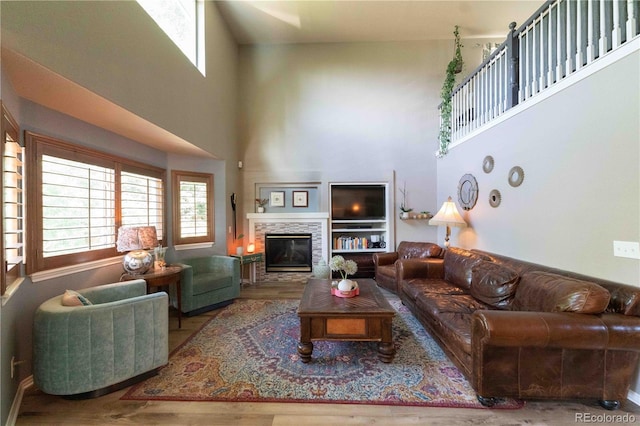 919 Taylor Ln, Erie, CO 80516 - living area featuring wood finished floors, a towering ceiling, and a stone fireplace